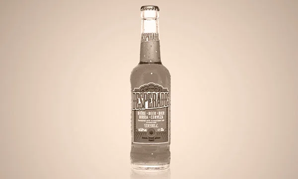 Photographie vintage en sépia d'une bouteille de bière Desperados, connue pour son arôme de tequila, avec des gouttelettes de condensation.