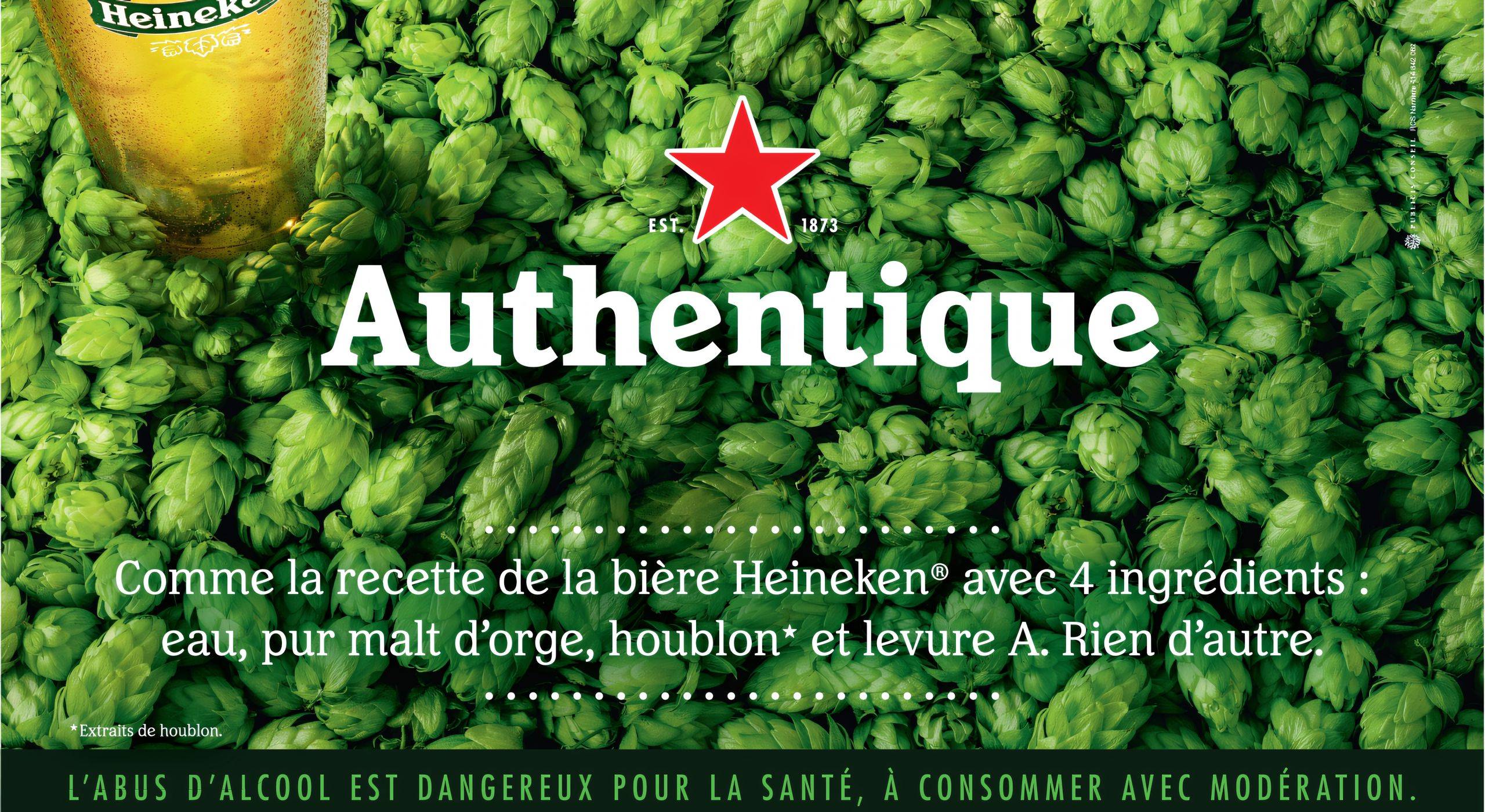 bandeau_heineken_upscayl_2x_ultramix_balanced Affiche publicitaire de Heineken avec un verre de bière et un fond de houblon vert, mettant en avant la recette authentique avec quatre ingrédients : eau, pur malt d’orge, houblon et levure A.